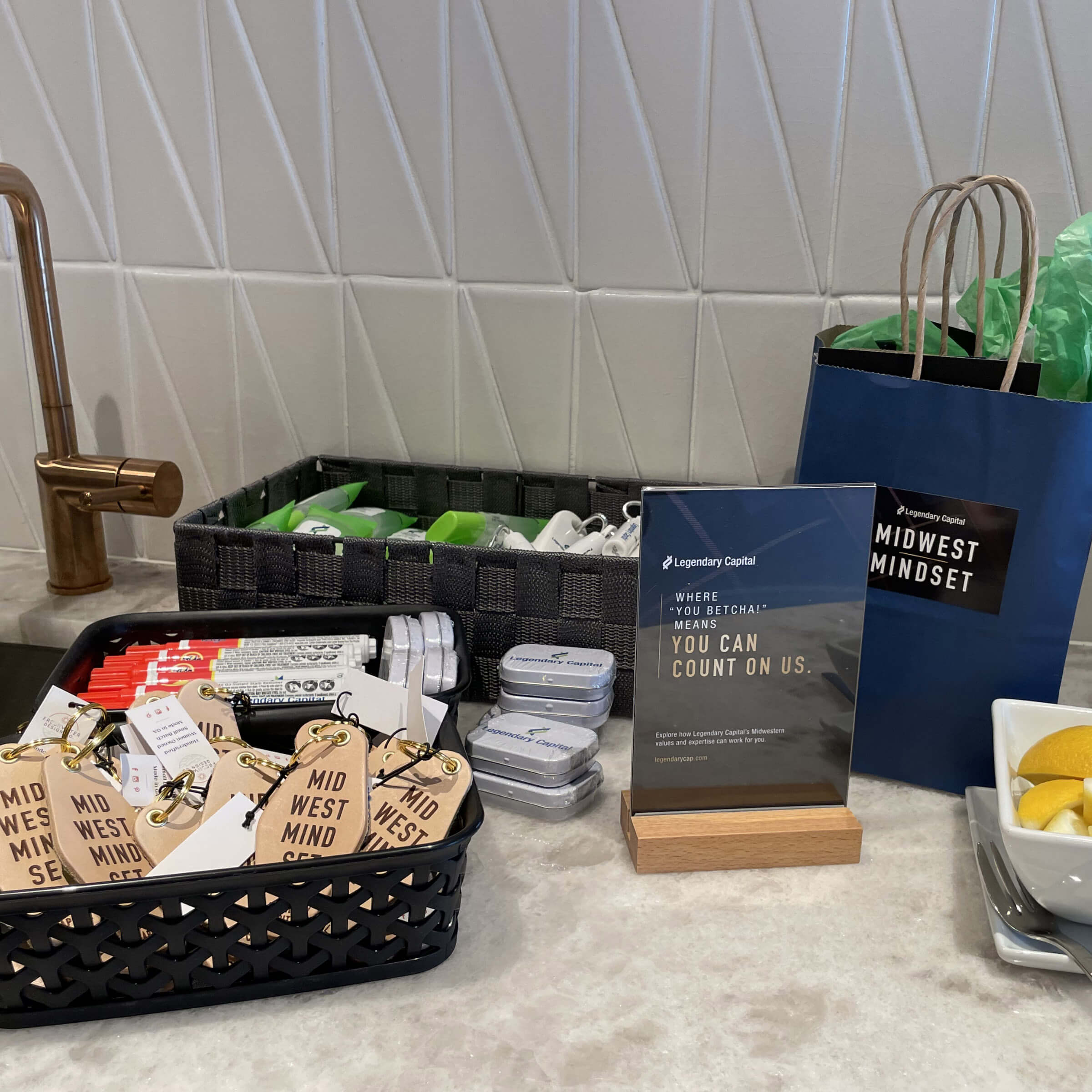 A table displaying keychains, mints, a table tent, and gift bags.